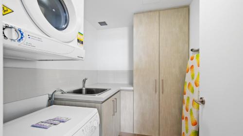 a small kitchen with a sink and a microwave at Bridgepoint 502 in Mandurah