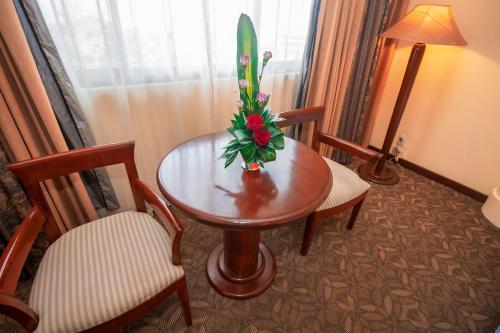 a room with a table and two chairs and a lamp at LAOTEL VIENTIANE in Vientiane