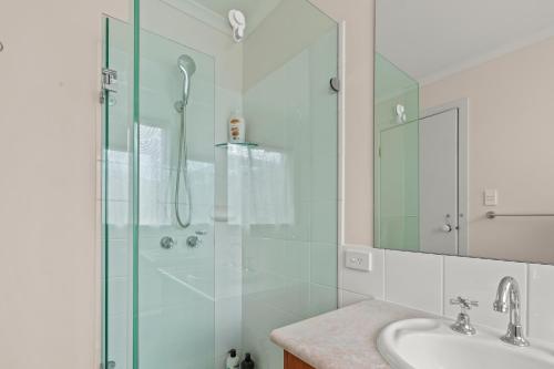 y baño con ducha acristalada y lavamanos. en StayAU Cozy Family Home 4BR Berwick, en Berwick