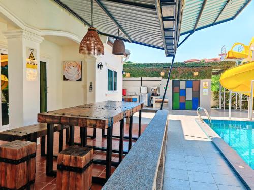 an outdoor dining area with a table and a swimming pool at Baan Big Family Pool Villa in Hua Hin