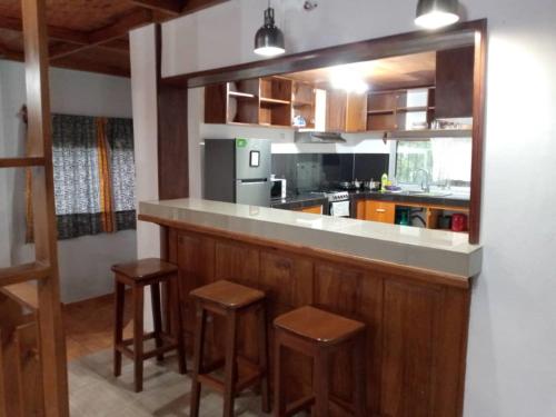 eine Küche mit einer Bar mit zwei Hockern und einer Arbeitsplatte in der Unterkunft La Maison Du Voyageur in Kribi