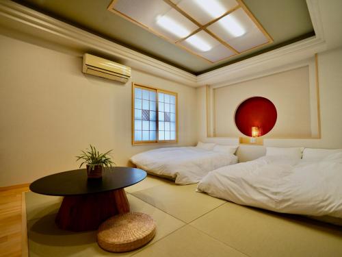 pokój z dwoma łóżkami i stołem w obiekcie Hotel Ishigaki and Chikonkiya w mieście Ishigaki