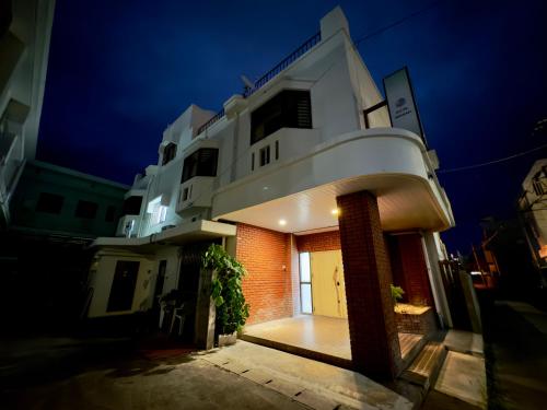 a large white building with a door at night at Hotel Ishigaki and Chikonkiya in Ishigaki Island