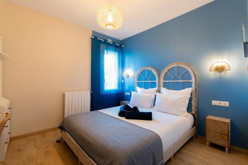 una camera da letto con un letto grande con una parete blu di La Petite Venise a Sète