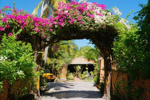 an archway with pink flowers in a garden at Hoang Nga Garden Guesthouse in Mui Ne