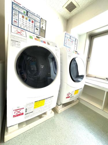 two washing machines in a room with a window at Day Nice Hotel Tokyo in Tokyo