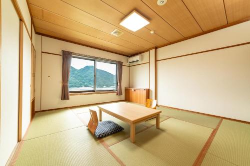 a room with a table and a window at Ooedo Onsen Monogatari Premium Kinosaki in Toyooka
