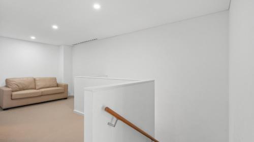 a living room with a couch and a staircase at Seapoint 109 in Mandurah
