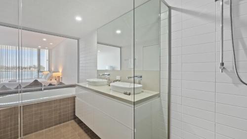 a white bathroom with a sink and a shower at Seapoint 109 in Mandurah