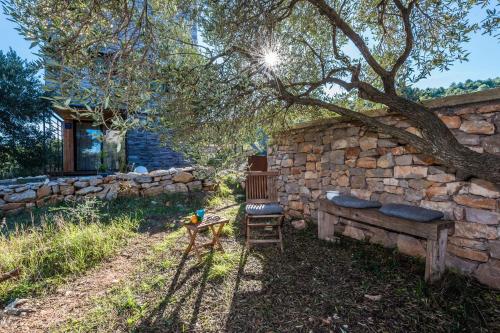 a stone wall with a bench and a tree at Villa Gordan - Happy Rentals in Dragove