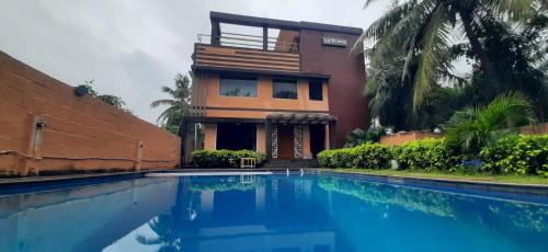 a house with a swimming pool in front of a building at Le Grace Beachview in Chennai