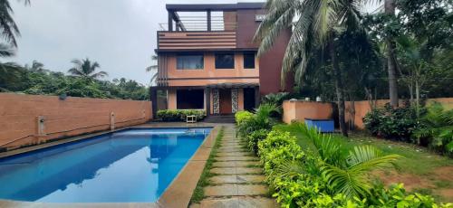 a house with a swimming pool in front of it at Le Grace Beachview in Chennai