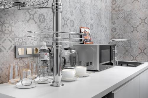 a kitchen counter with a coffee maker and a microwave at Apart Hotel Colibri in Almaty