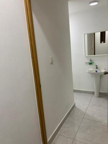 a white bathroom with a sink and a mirror at Villa de Lujo con Picsina Privada in San Pedro de Macorís