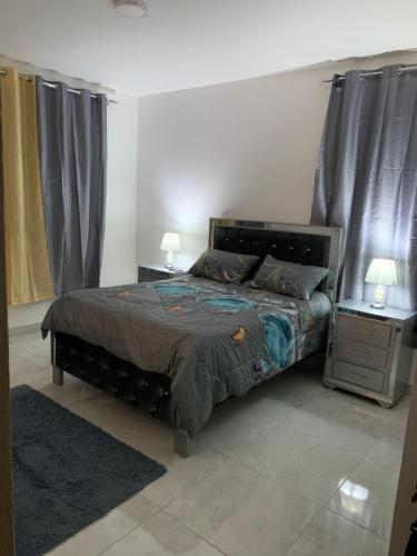 a bedroom with a large bed and two night stands at Villa de Lujo con Picsina Privada in San Pedro de Macorís