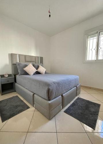 a bedroom with a bed with two rugs on it at Quartier Administratif in Tetouan