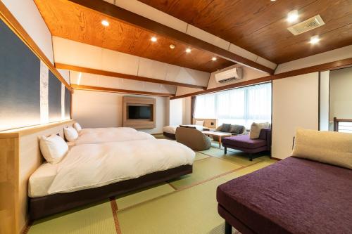 a bedroom with a bed and a living room at Ooedo Onsen Monogatari Premium Kinosaki in Toyooka