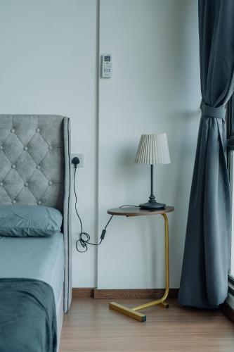 a bedroom with a bed and a table with a lamp at SUMMER SUITES APARTMENT CASETTA HOMESTAY 1 at Kota Samaraham Kuching in Kota Samarahan