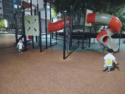 due bambini che passeggiano in un parco giochi di The Ken & Hiro Stay a Sepang