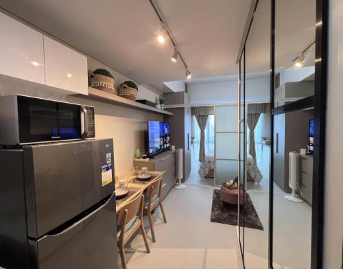 a kitchen with a refrigerator and a table at 38 Park Avenue Condominium Cebu IT Park - Unit Freyja in Cebu City