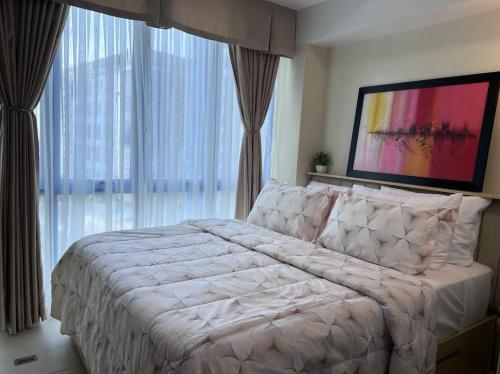 um quarto com uma cama grande e uma janela grande em 38 Park Avenue Condominium Cebu IT Park - Unit Freyja em Cebu