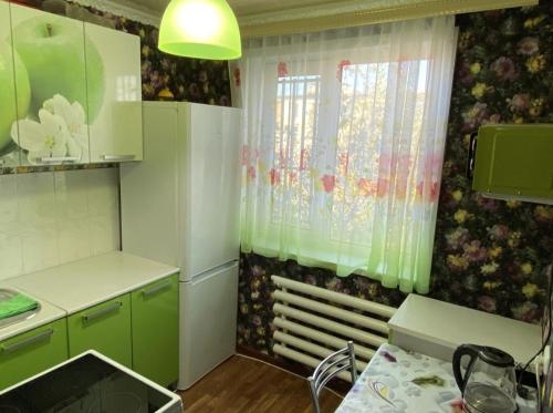 a kitchen with green cabinets and a window at Мангилик ел 19 in Sätbaev