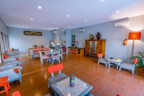 a living room with blue walls and orange chairs at Rama Residence Petitenget in Seminyak