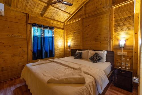 ein Schlafzimmer mit einem Bett in einem Holzzimmer in der Unterkunft Hitide Beach Resort in Palolem