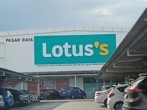 a sign for a lotus car dealership with parked cars at WY Impian Homestay in Bukit Mertajam