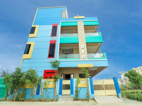 um edifício azul com palmeiras em frente em OYO Flagship Sea Coastal Inn em Kakinada