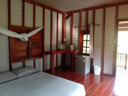 a room with a bed and a bird flying over it at Cha Bungalow in Ko Yao Noi