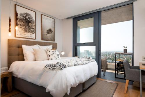 een slaapkamer met een groot bed en een groot raam bij Umhlanga Arch, Luxury Sea View Apartment in Durban