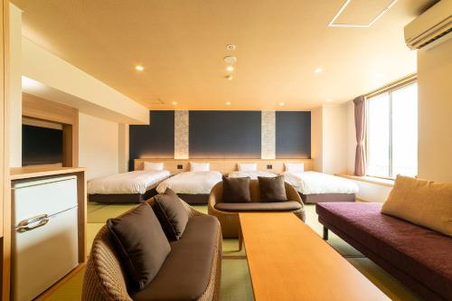 a hotel room with three beds and a couch at Ooedo Onsen Monogatari Premium Kinosaki in Toyooka