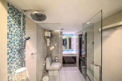 a bathroom with a shower and a toilet and a sink at 普吉岛-安达曼海难海景酒店 Phuket-Andaman Beach Seaview Hotel in Patong Beach