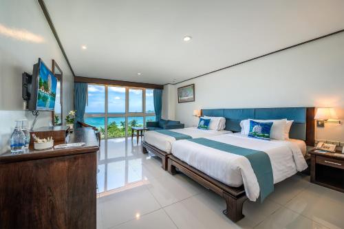 um quarto com uma cama grande e uma varanda em 普吉岛-安达曼海滩海景度假酒店 Phuket-Andaman Beach Seaview Hotel em Praia de Patong