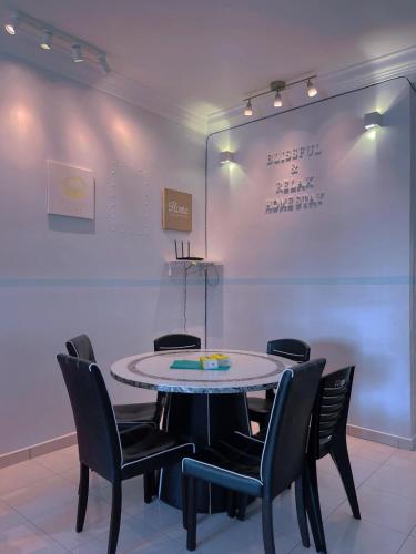a table and chairs in a room with a white wall at Afini Homestay Cameron Highlands in Tanah Rata