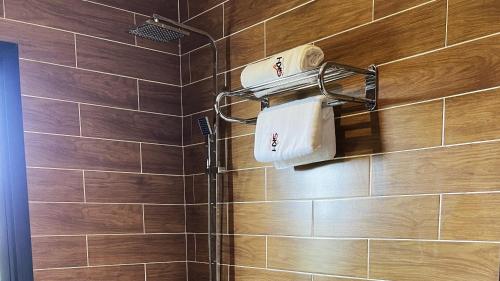 a bathroom with a shower with brown tiles at SKY KENAKO HOTEL in Kribi