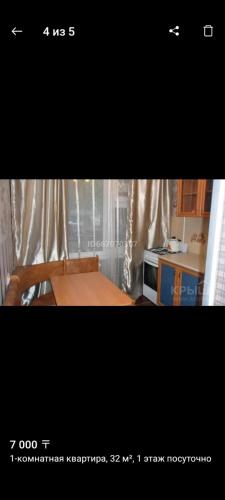 a picture of a kitchen with a table and a microwave at Квартира in Oral