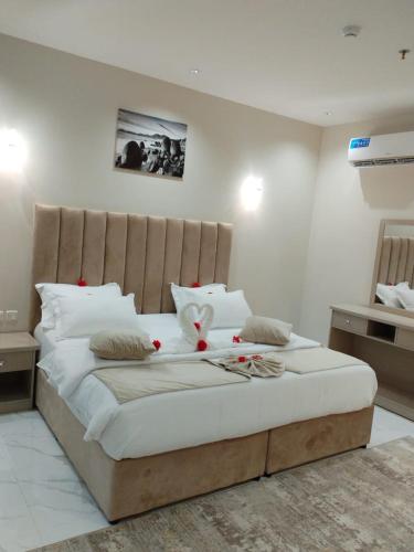 a bedroom with a large white bed with a headboard at العلي للشقق المخدومة Alalihotel in Hafr Al Baten