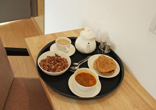 um tabuleiro preto com comida para o pequeno-almoço numa mesa em Heritage Home By BYOB HOTELS em Nova Deli