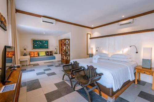 a bedroom with a large bed and two chairs at Rama Residence Petitenget in Seminyak