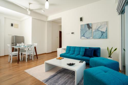 a living room with a blue couch and a table at La Privé Apartments Havelock in Colombo
