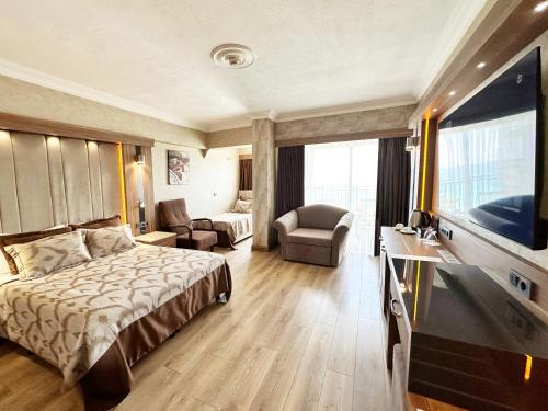 a hotel room with a bed and a television at LAUR HOTELS Experience & Elegance in Didim