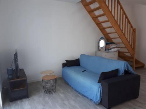 a living room with a blue couch and a staircase at Duplex 5 p 40m2 jardin de 50m2 in Six-Fours-les-Plages