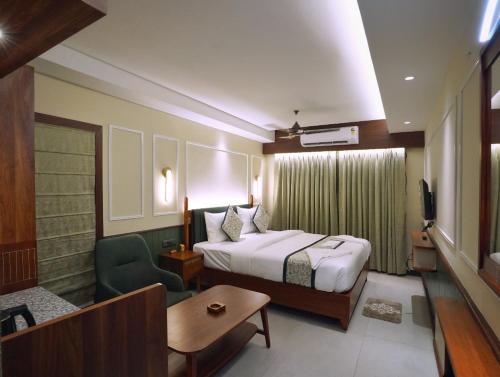 a hotel room with a bed and a chair at Hotel Sonar Bangla Puri in Puri