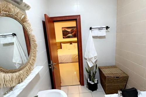 baño con lavabo, espejo y cama en Prive Apartments Katampe Extension 3bed, en Abuja