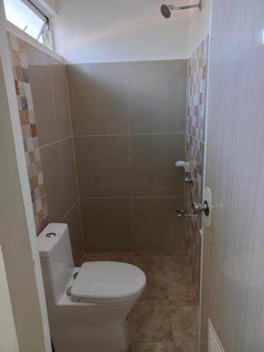 CELCOR PENSION HOUSE في Cabatuan: حمام صغير مع مرحاض ودش