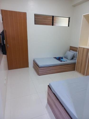 um pequeno quarto com uma cama e uma porta em CELCOR PENSION HOUSE em Cabatuan
