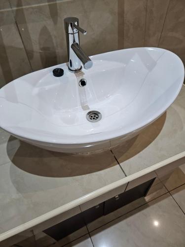 lavabo blanco en la encimera del baño en Booth Suite Hotel Mafikeng en Mafikeng