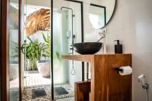 uma casa de banho com um lavatório e um espelho em KIKI VILLAGE PADDY FIELD em Canggu